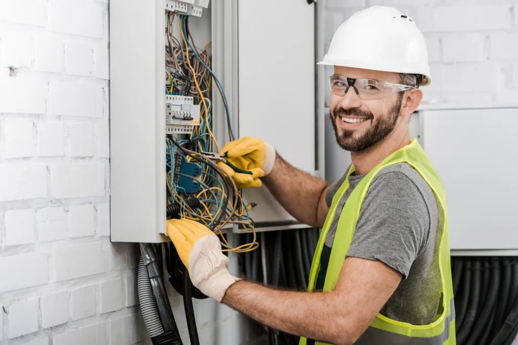 Eletricista consertando painel elétrico